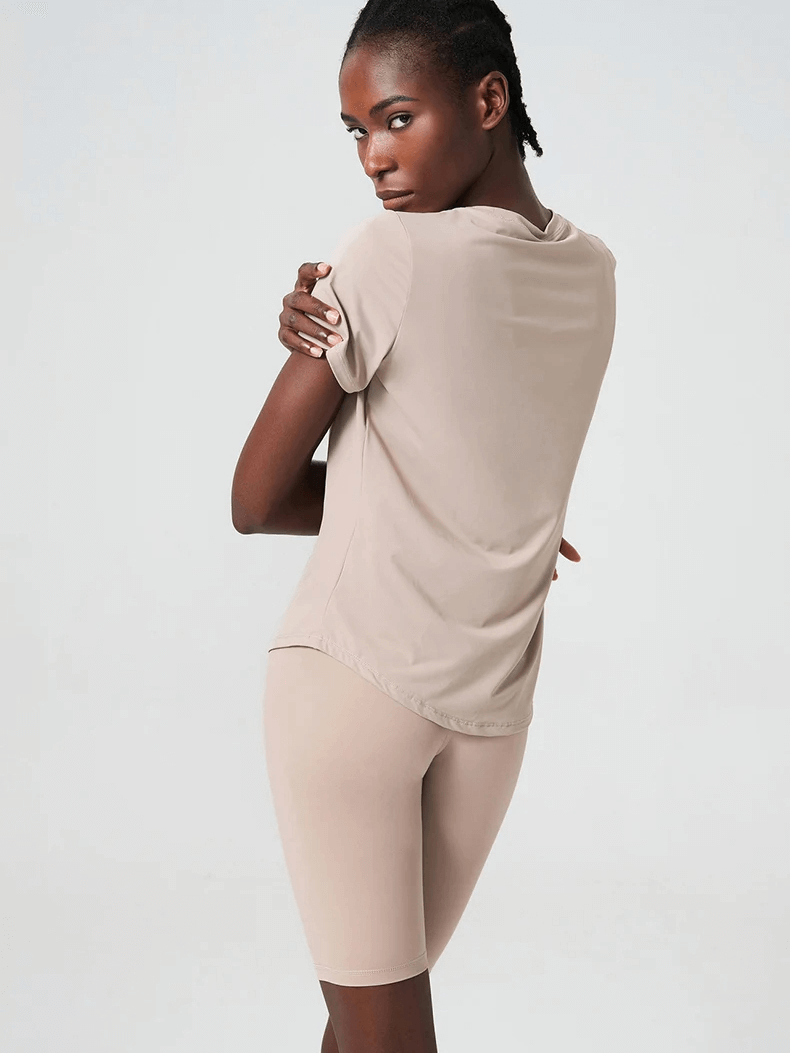 Back view of woman in solid color yoga set, featuring short sleeves and breathable fabric, ideal for gym, running, or yoga workouts SF2079.